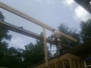 Carpenter setting a ridge beam over a new addition frame — Ice Dam Removal by Roofing Brothers in Noblesville
