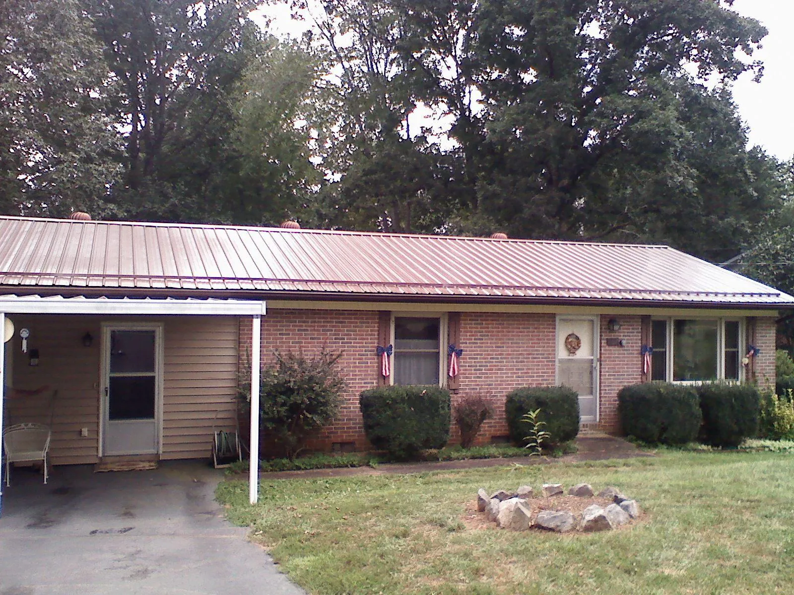 Bronze metal roof and carport on a brick ranch home — Roof Repair work by our crew in Noblesville